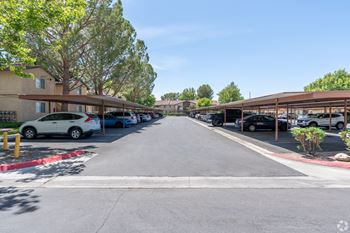 an empty parking lot with cars parked on the side of a building